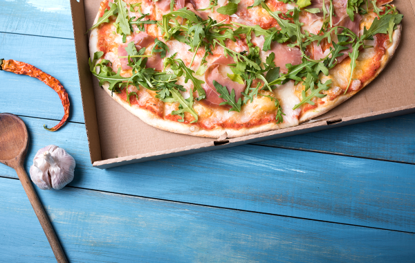 Pinsa met tomatensaus, kaas, ham en afgewerkt met rucola / Pinsa avec sauce tomate, fromage, jambon et salade de roquette